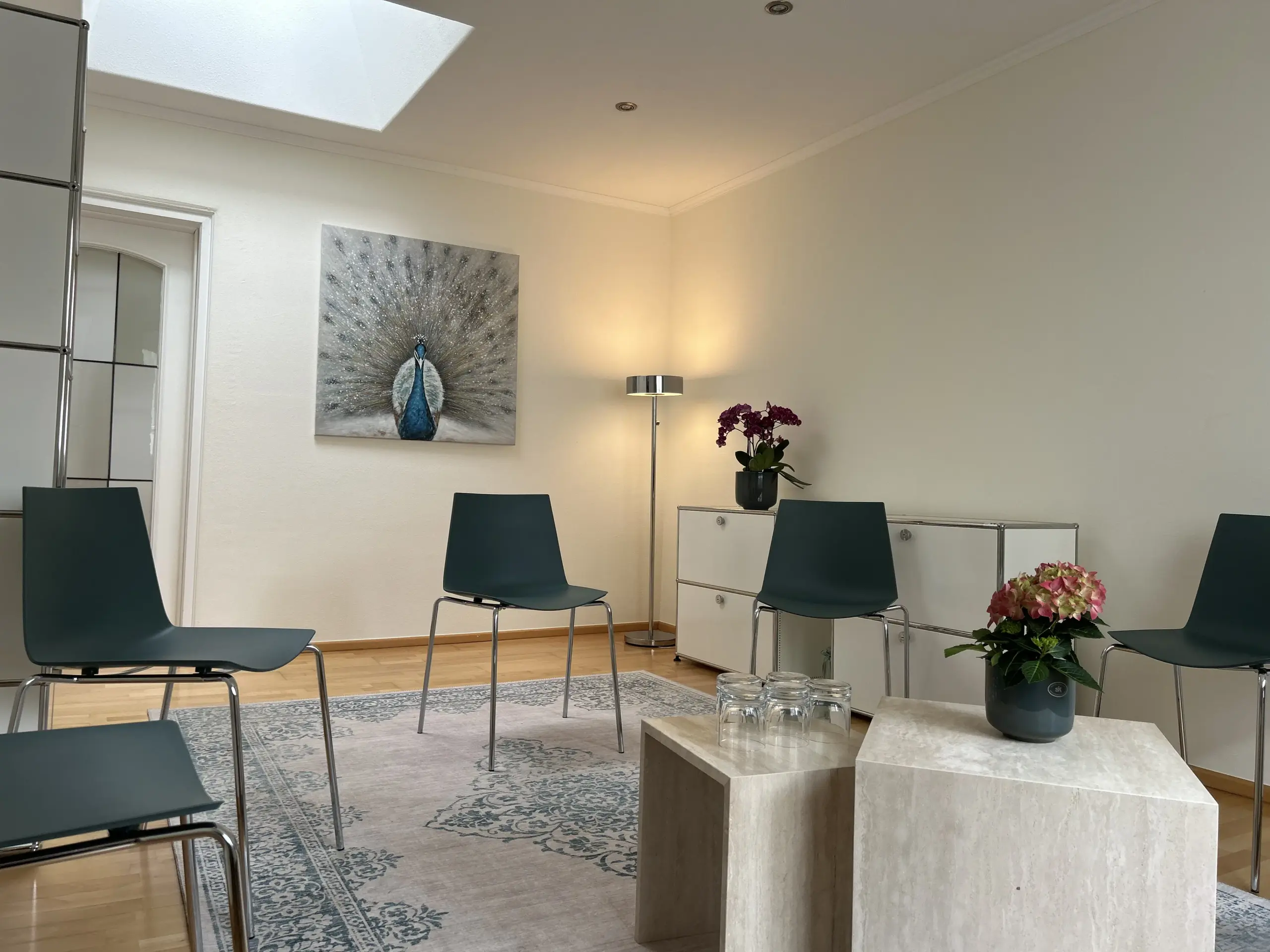 Heller und freundlicher Gruppenraum der psychotherapeutischen Praxis in Dortmund-Hombruch mit Sitzkreis, Teppich und ruhiger Atmosphäre.